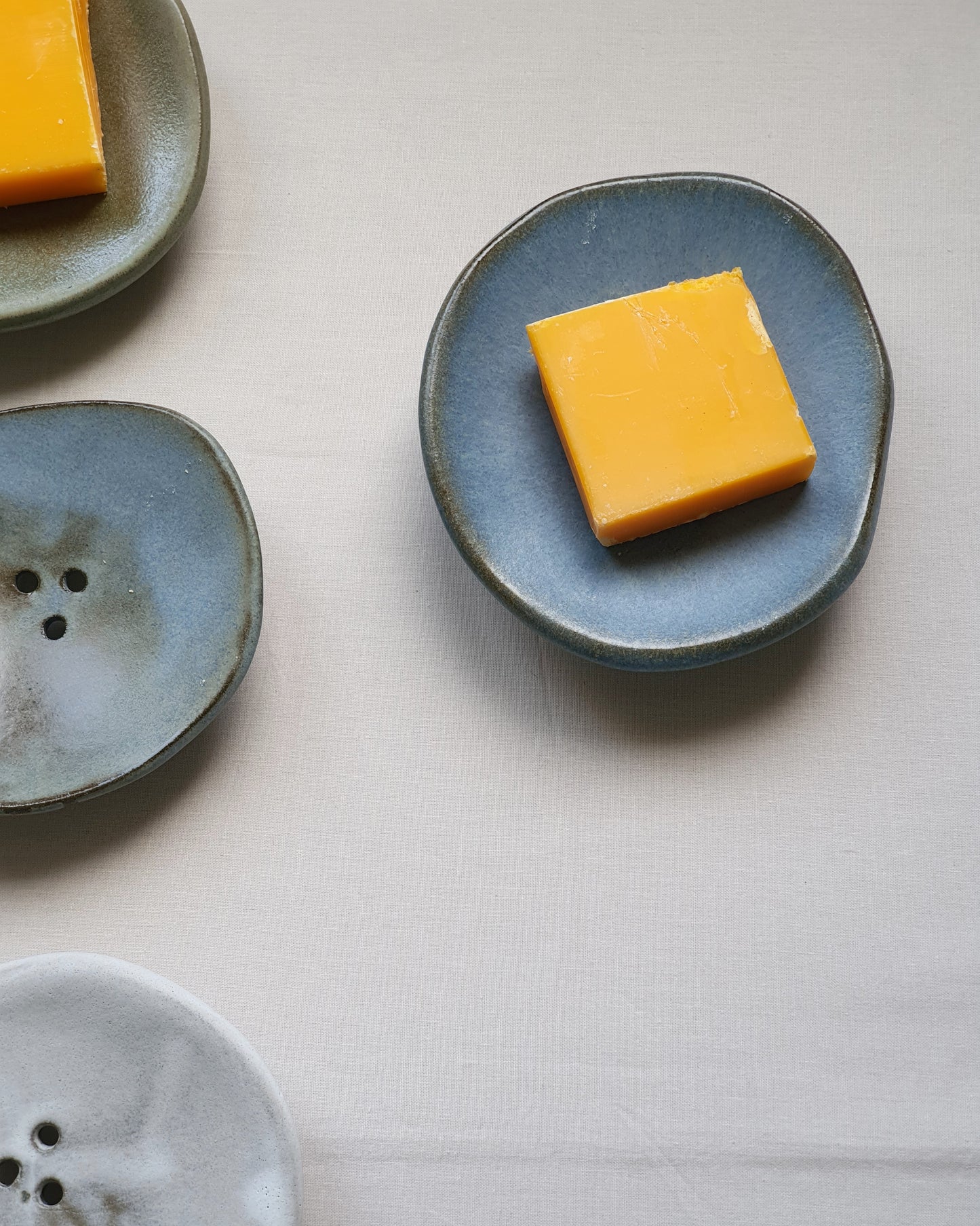 PORTA SAPONE di forma organica con piedini in gres nero di diversi colori e dimensioni