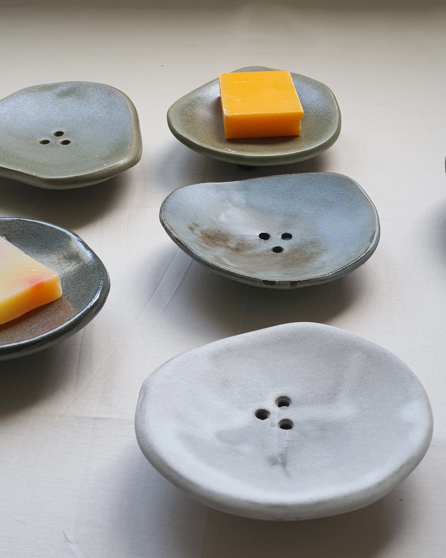 PORTA SAPONE di forma organica con piedini in gres nero di diversi colori e dimensioni