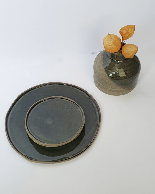 Piatto in gres grigio smaltato internamente di un blu petrolio cangiante.