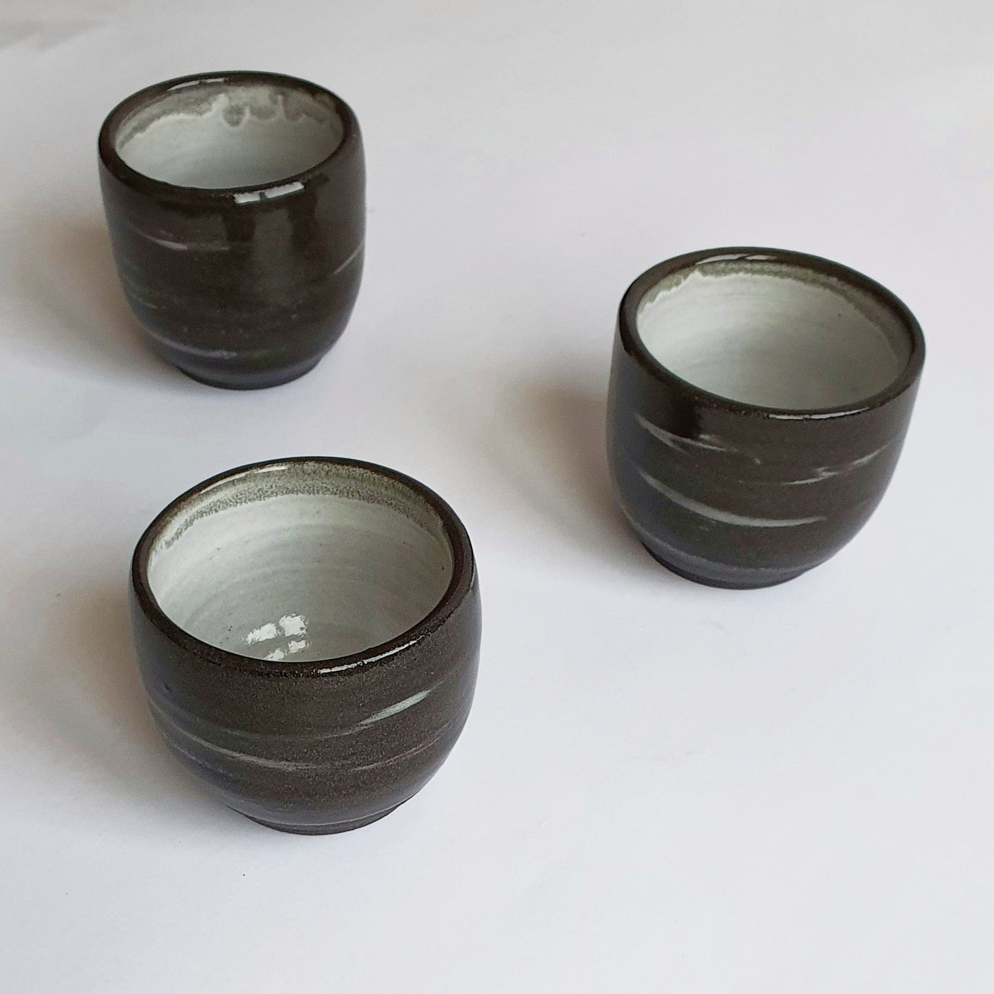 Tazza GN1 da caffè in gres nero , smaltato di bianco dentro e trasparente fuori.